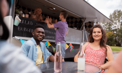 a man and woman dinning in a street food truck